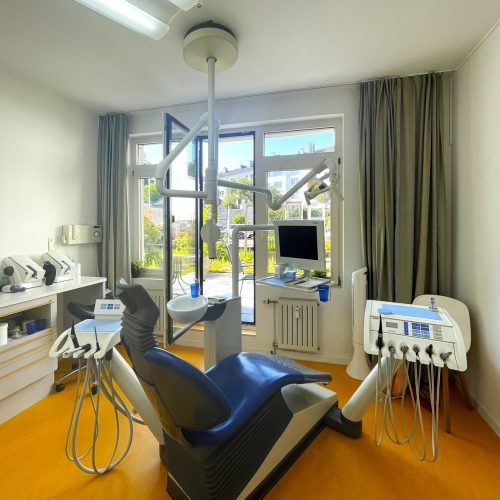 Ein Behandlungszimmer in der Zahnarztpraxis Werner Schippers mit einem blauen Behandlungsstuhl.