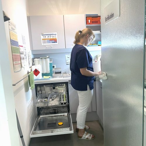Eine zahnmedizinische Fachangestellte arbeitet im Sterilisationsraum.